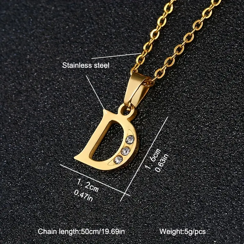 The Stainless Steel Letter Necklace showcases a gold chain that is 50 cm (19.69 inches) long, complemented by a dazzling pendant shaped like the letter “D” and adorned with three small diamonds. The pendant measures 1.2 cm in width and 1.0 cm in height, with the overall necklace weighing only 5 grams.