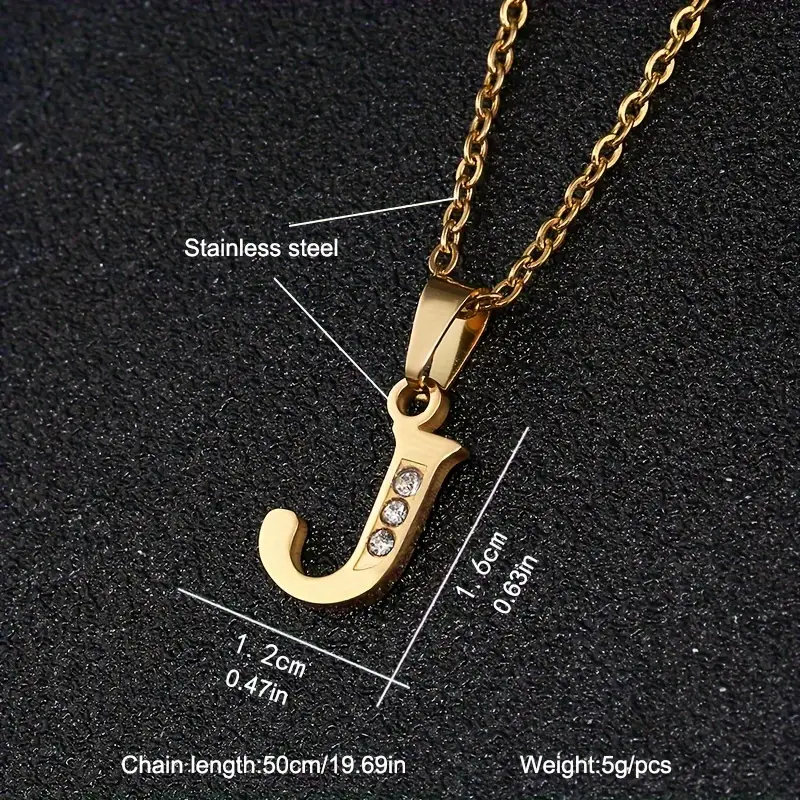 The Stainless Steel Letter Necklace showcases a pendant shaped like the letter “J,” adorned with three small diamonds. The pendant dimensions are 1.2 cm (0.47 inches) by 1.6 cm (0.63 inches), weighing 5 grams and made from durable stainless steel. The necklace features a gold chain with a length of 50 cm (19.69 inches).