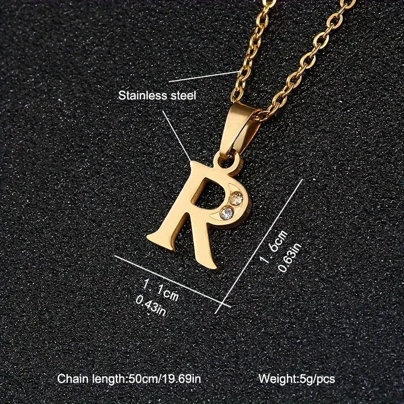 The Stainless Steel Letter Necklace is an elegant piece featuring a gold-colored stainless steel pendant in the shape of “R,” adorned with a small embedded crystal. The pendant measures 1.6 cm in height and 1.1 cm in width, while the chain is 50 cm (19.69 inches) long and weighs just 5 grams.