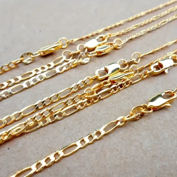 Close-up of the Gold-Plated 4mm Flat Chain Necklace – Adjustable 16-30in, sleek and versatile jewelry for women, laid out parallel to other gold chains on a beige surface. Each chain showcases different link designs and secure lobster clasps. The gold chains glisten slightly under the lighting.