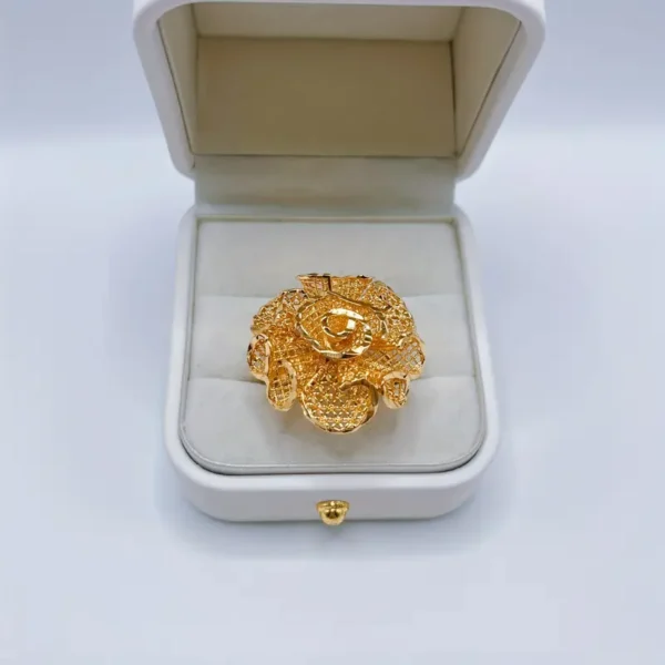 The Exquisite Flower Open Ring, a luxurious piece made from golden luxury copper and perfect for romantic gifts, is displayed in an open white jewelry box with a cushioned interior. Centered to showcase its craftsmanship and elaborate design, this elegant proposal jewelry piece shines against the soft background of the box.