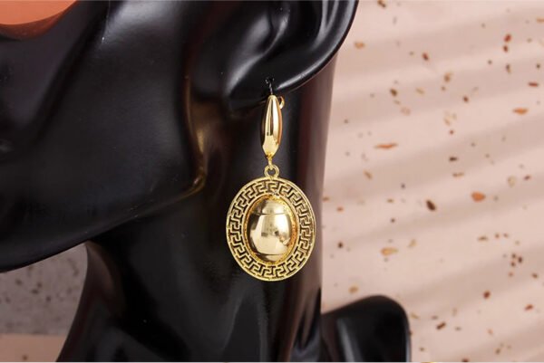 a gold earrings on a black mannequin