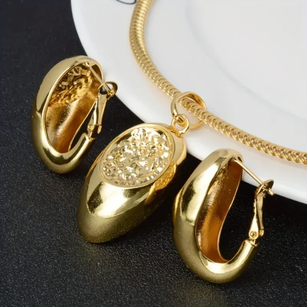 a gold necklace and earrings on a white plate