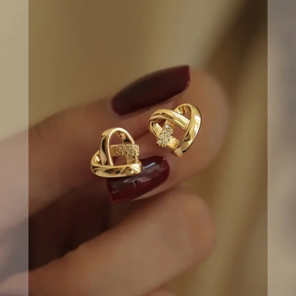 a hand with painted nails and gold earrings