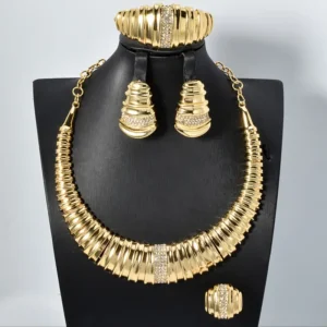 a gold necklace and earrings on a black mannequin