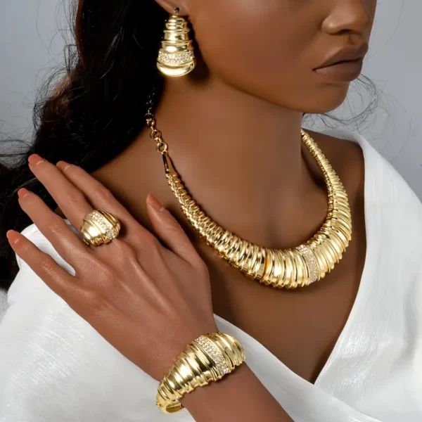 a woman wearing a gold necklace and earrings