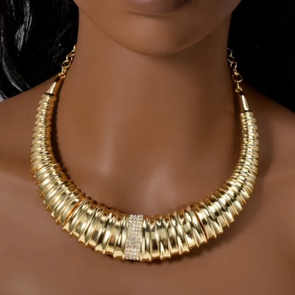 a gold necklace on a mannequin